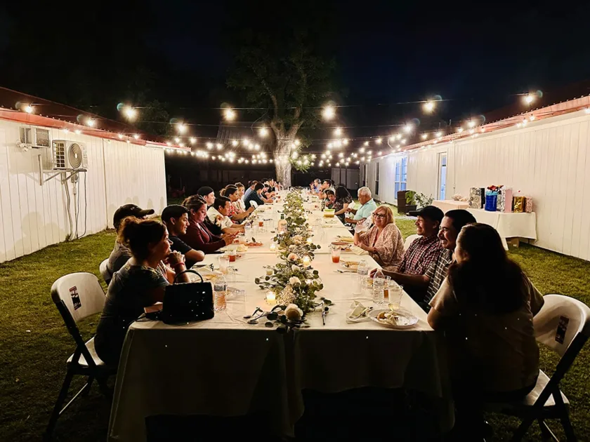 Warm Outdoor Long Table Angle View Leaves Garland Angle View Dark Nigh String Lights